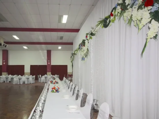 A long table with white tablecloth and chairs